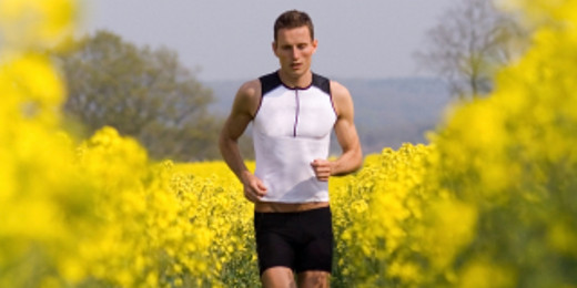 Mann trägt Triathlon-Anzug auf gelbem Rapsfeld