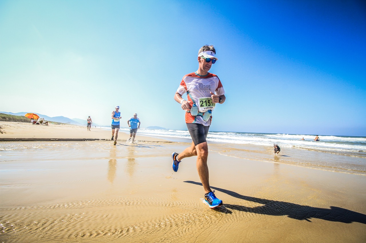 Ein Triathlet beim Laufen an einem Strand bei schönem Wetter.